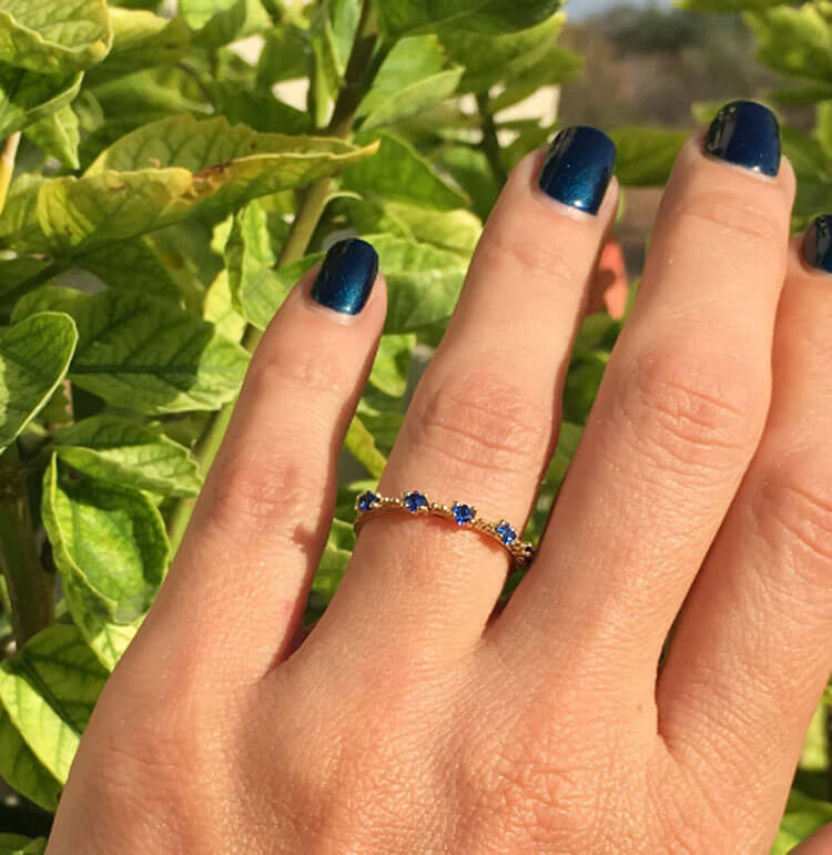 This blue sapphire scalloped band aligns any look with the confidence-boosting energy of blue sapphires. In the shapely band houses expertly-set gemstones, 5 square shaped blue sapphires displaying indigo rays.
