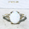 Exquisiter, hübscher Damenring mit weißem Opal im Ovalschliff, besetzt mit 6 klaren Quarzen im Rundschliff.