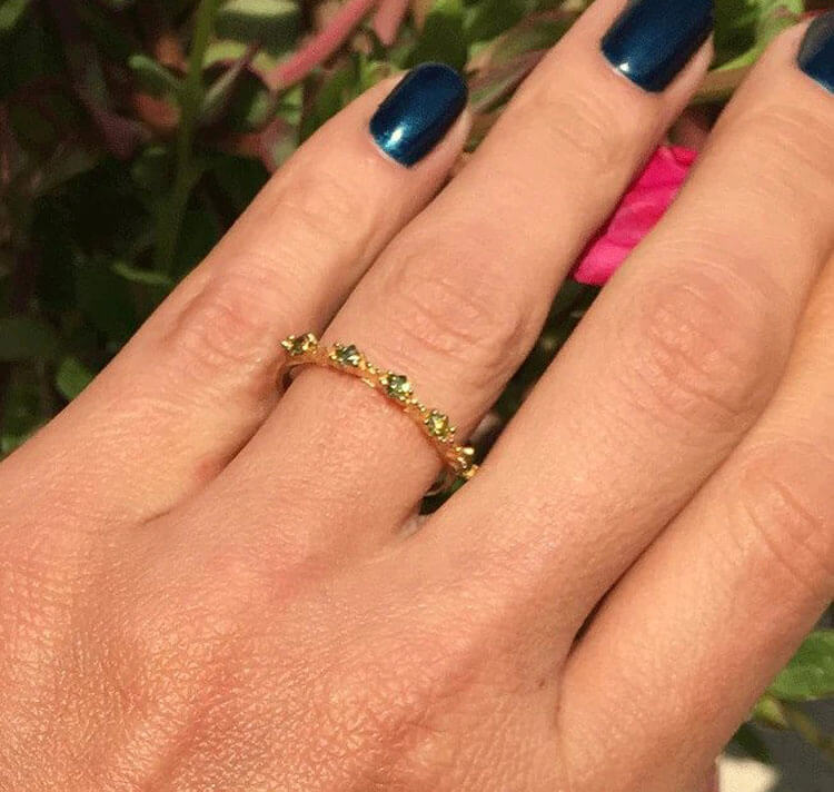 Dieser wunderschöne Ring zeigt schlichte Eleganz in seinem Design. In dem formschönen Band befinden sich fachmännisch gesetzte Edelsteine, 5 quadratische Peridots.