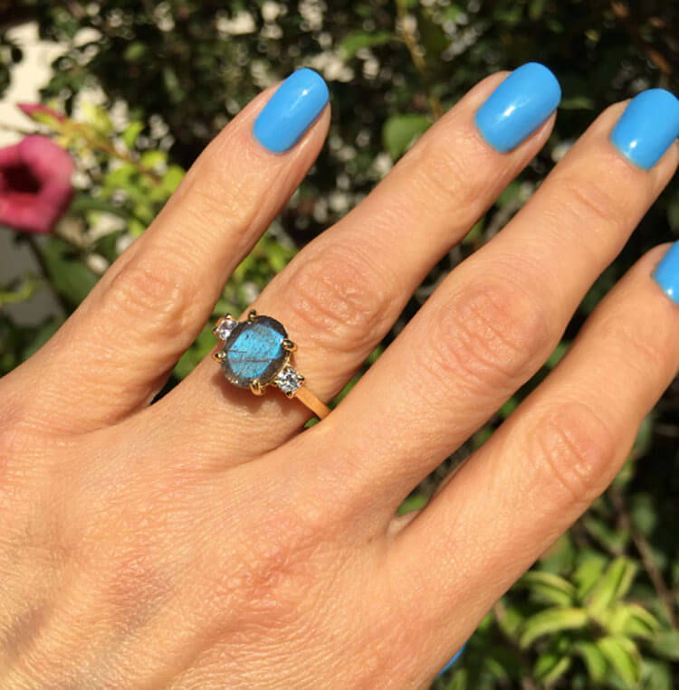 An absolute stunner, classic natural labradorite engagement ring with an oval cut gemstone of your choice as it’s centre stone and with round cut clear quartz on the band to further accentuate it.