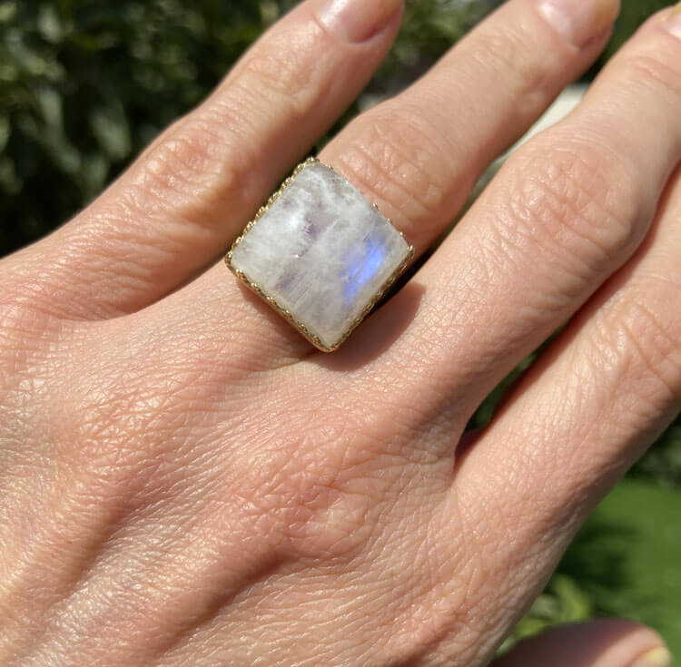 טבעת עוצרת ראווה זו, הכוללת אבן חן אמיתית קשת בענן מרובעת בתוך עיצוב כתר מרובע.