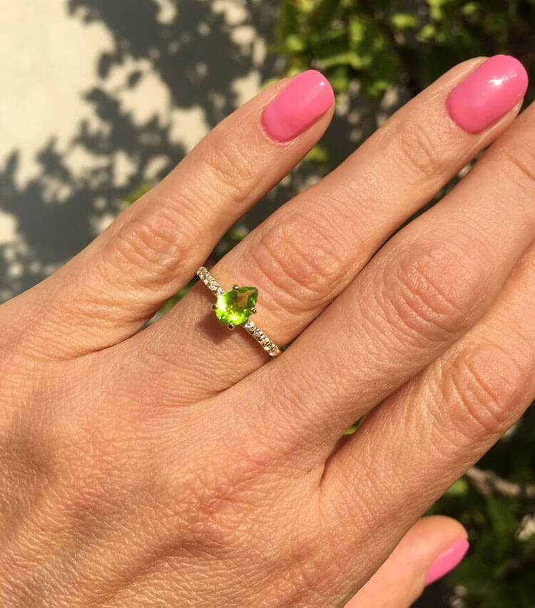An absolute stunner, classic natural peridot engagement ring with a pear cut gemstone of your choice as it’s centre stone and with round cut clear quartz on the band to further accentuate it.