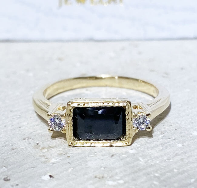 This gorgeous and elegant women's ring features an octagon-cut natural onyx gemstone with two round-cut dazzling clear quartz. This beautiful ring is enhanced with a high polish finish.