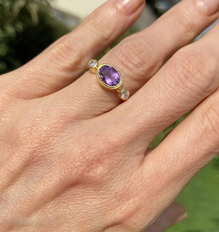 Exquisite, lovely women's oval cut natural amethyst ring set with 2 round cut clear quartz. This ring exudes glamour and the traditional design ensures that it can be worn for many years to come to add a stylish touch to an evening look.