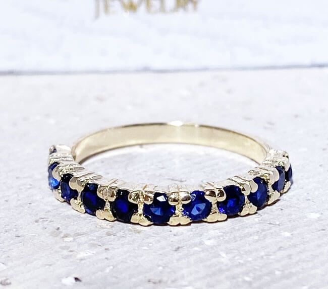 This blue sapphire scalloped band aligns any look with the confidence-boosting energy of blue sapphires. In the shapely band houses expertly-set gemstones, 11 round shaped blue sapphires displaying indigo rays.