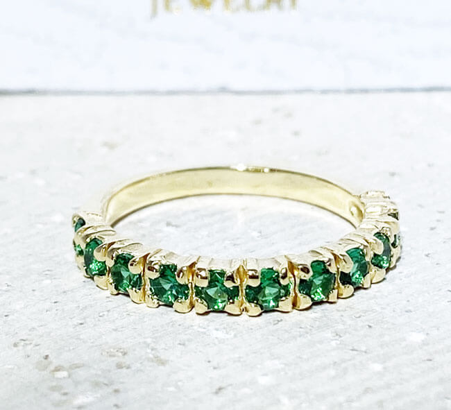This stylish emerald half eternity ring is beautifully displayed, the fine craftsmanship shows off the row of emeralds, and their stunning sparkle. It's a beautiful gift ring for anybody who loves gemstones.