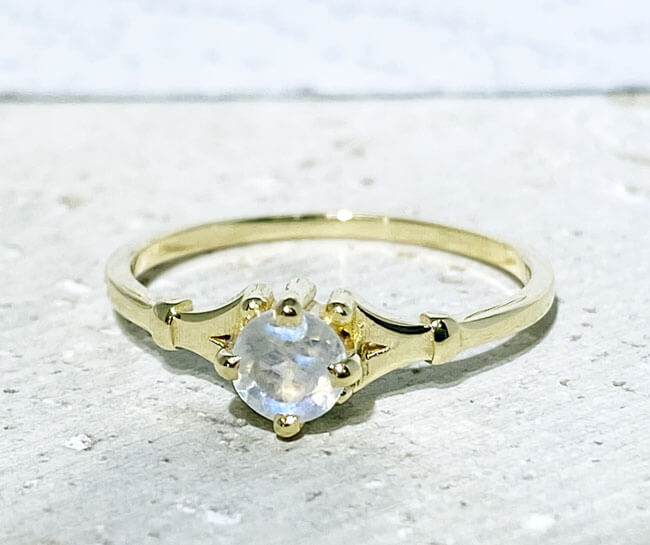 This gorgeous moonstone ring displays simple elegance in its design. The ring features a round-cut natural rainbow moonstone and finished with a delicate band.