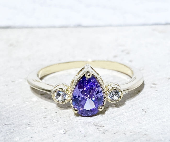 Это великолепное и элегантное женское кольцо украшено грушевидным лавандовым аметистом и двумя ослепительно прозрачными кварцами круглой огранки. Это красивое кольцо отполировано до блеска.