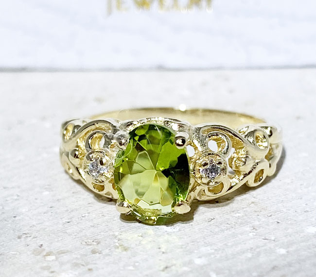 Exquisite, lovely oval cut genuine peridot ring set with 2 round cut clear quartz.