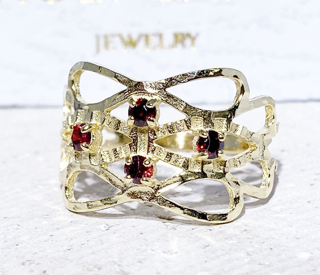 This gorgeous garnet ring displays simple elegance in its design. The ring features a round-cut natural red garnet gemstones and finished with a hammered band.