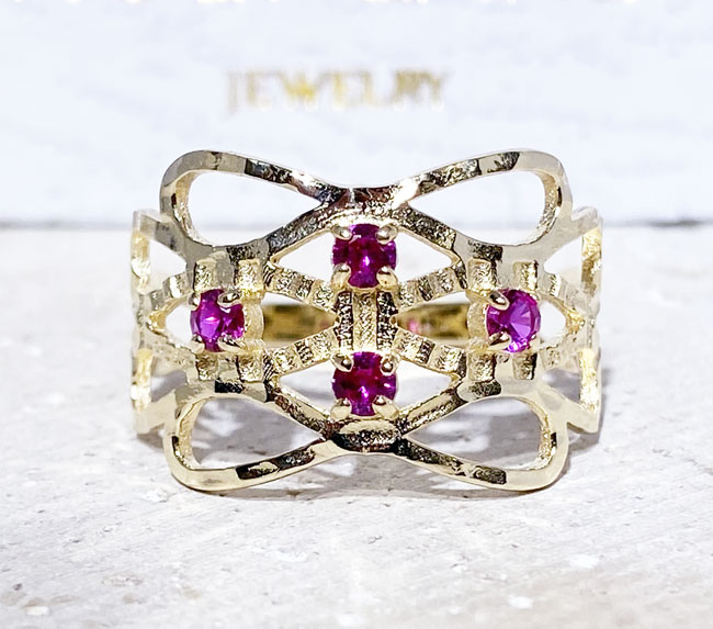 This gorgeous ruby ring displays simple elegance in its design. The ring features a round-cut ruby gemstones and finished with a hammered band.