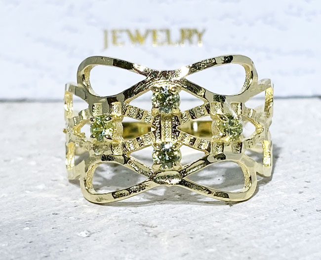 This gorgeous peridot ring displays simple elegance in its design. The ring features a round-cut green peridot gemstones and finished with a hammered band.