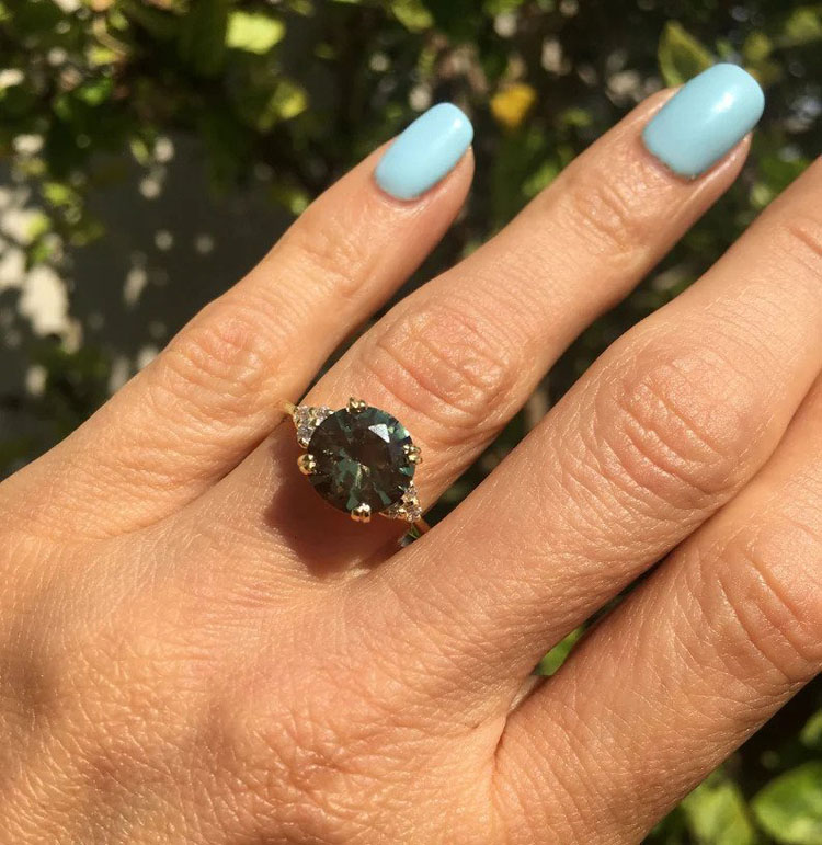 An absolute stunner, classic green tourmaline engagement ring with a round cut gemstone of your choice as it’s centre stone and with round cut clear quartz on the band to further accentuate it.