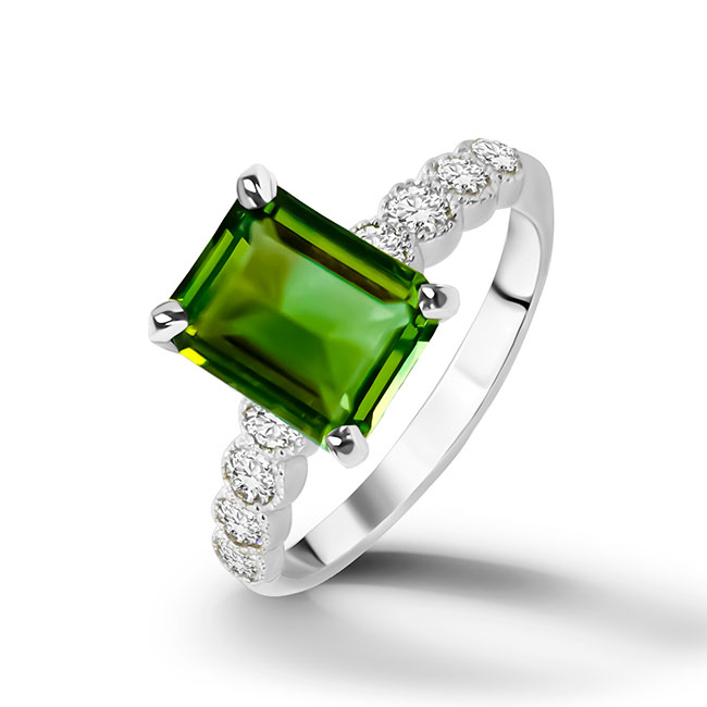 An absolute stunner, classic green tourmaline engagement ring with an emerald cut gemstone of your choice as it’s centre stone and with round cut clear quartz on the band to further accentuate it.