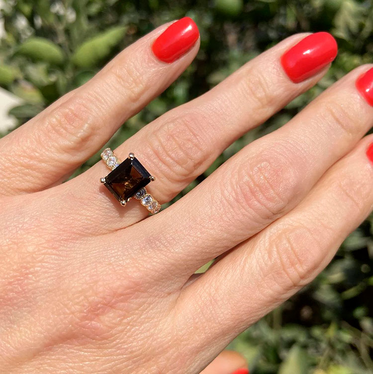 An absolute stunner, classic natural smoky quartz engagement ring with an emerald cut gemstone of your choice as it’s centre stone and with round cut clear quartz on the band to further accentuate it.
