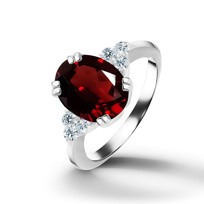 An absolute stunner, classic natural red garnet engagement ring with an oval cut gemstone of your choice as it’s centre stone and with round cut clear quartz on the band to further accentuate it.